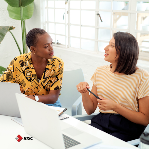 Two women employees conversing and giving each other feedback. 